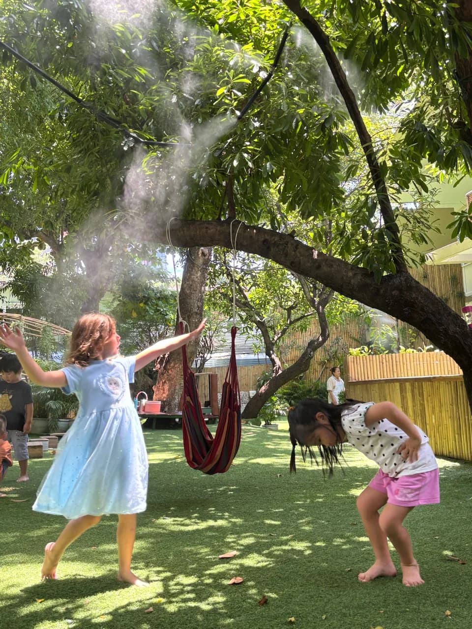 Children moving and playing together in Annabel's leafy garden